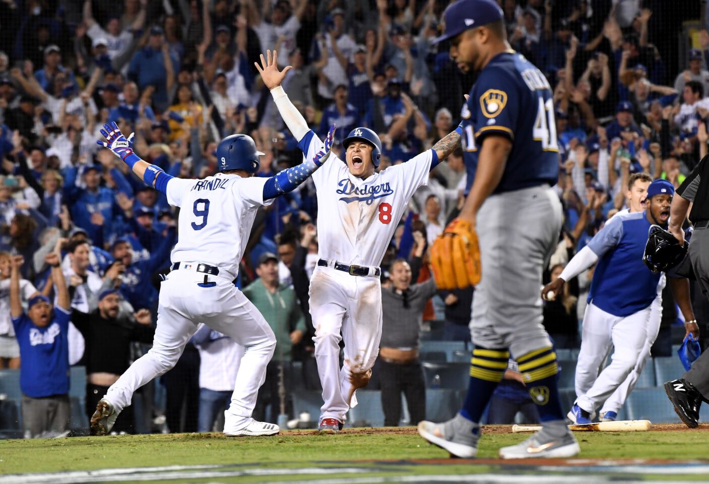 Dodgers Manny Machado scores the winning run off of Cody Bellinger's single in the 13th inning against the Brewers in Game 4 of the NLCS at Dodger Stadium Tuesday.