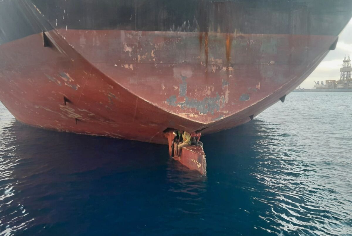 tres hombres son fotografiados en un petrolero anclado en un puerto en Islas Canarias, España. 