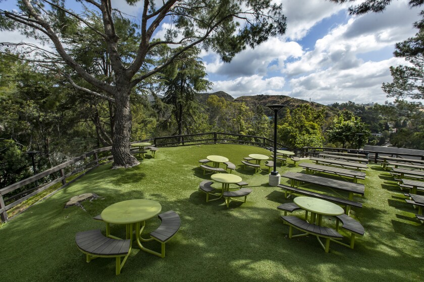 A green hilltop covered in picnic tables