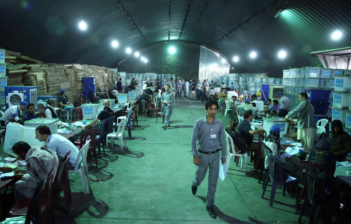 Afghan election workers sort ballots for an audit of the presidential runoff in front of international observers at a warehouse in Kabul on Aug. 27.