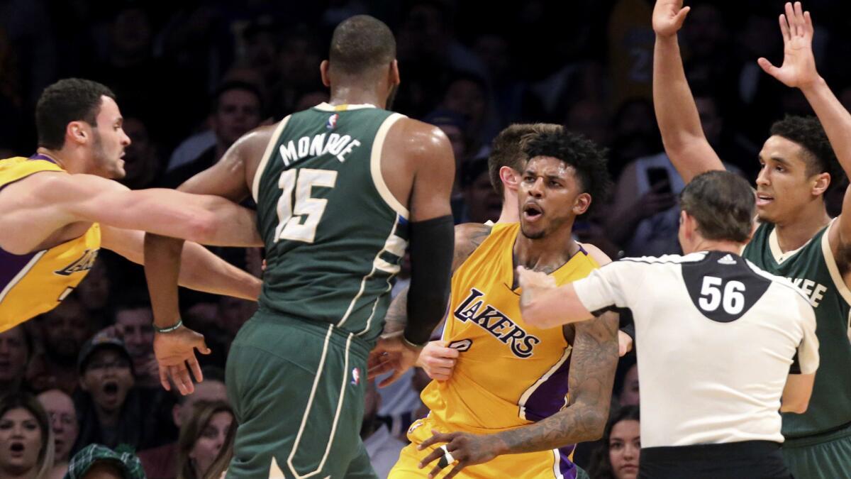 Lakers guard Nick Young, center, and Bucks center Greg Monroe are separated after getting into a shoving match when Young was fouled by Malcolm Brogdon, hands raised, during the third quarter Friday.