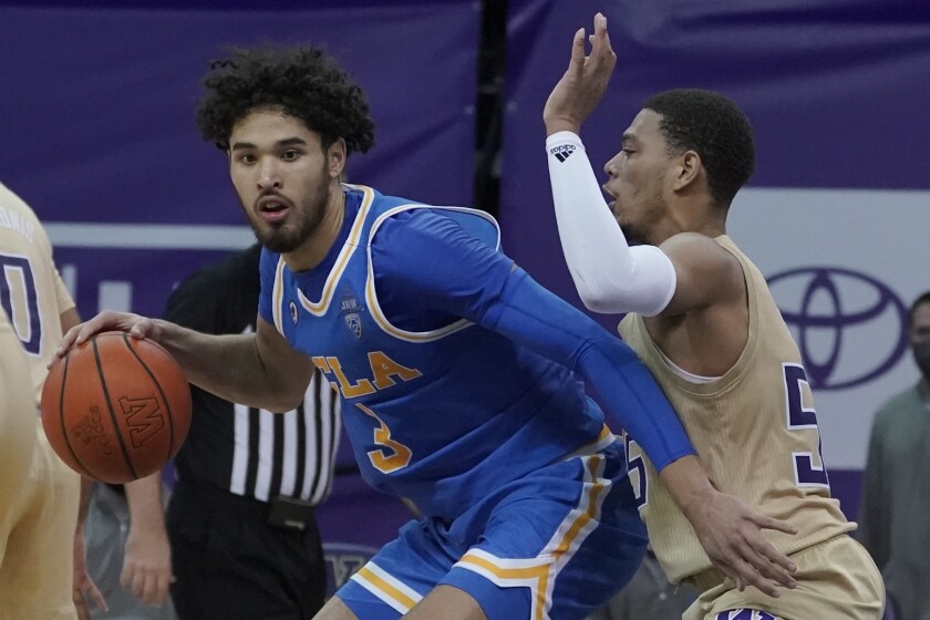 UCLA guard Johnny Juzang, left, guarded by Washington's Quade Green