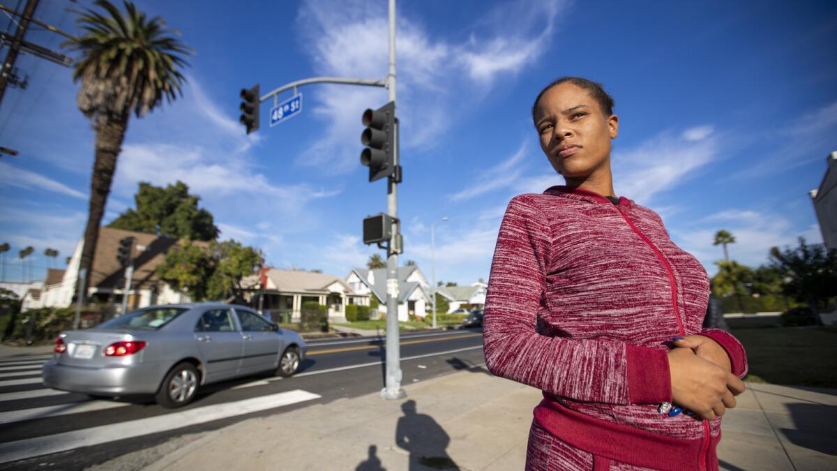 Precious McLaughlin stands at the busy intersection of West 48th Street and Arlington Avenue, near her South L.A. home.