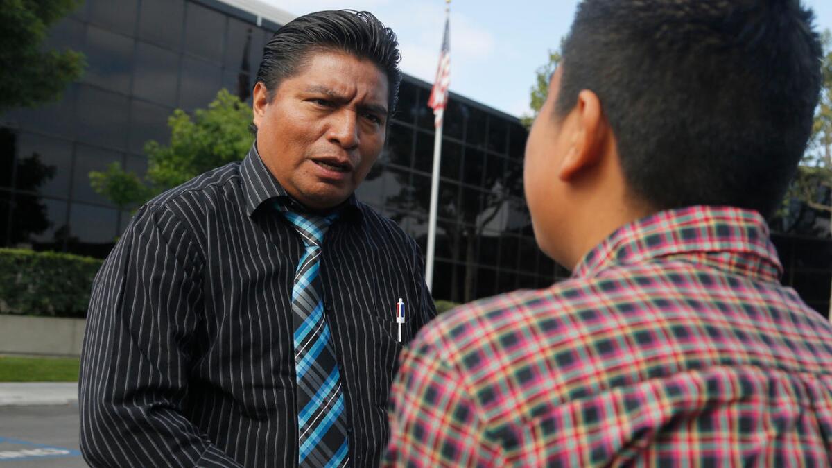 Aldo Waykam, intérprete de lengua maya, se reunió con Vinicio Nicolás, de 15 años, frente a la corte federal de inmigración en Anaheim, antes de la audiencia de asilo del joven, quien habla kanjobal, el lenguaje empleado en su pueblo de Guatemala.