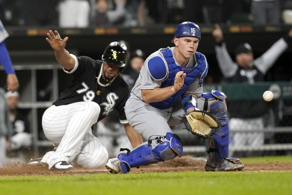 The White Sox's Jose Abreu scores as Dodgers catcher Will Smith waits for the throw.