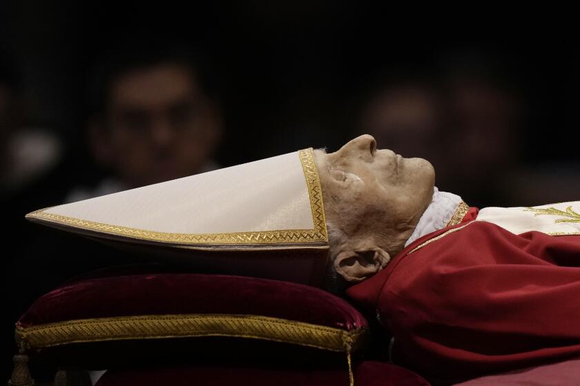 The body of late Pope Emeritus Benedict XVI laid out in state inside St. Peter's Basilica at The Vatican, Monday, Jan. 2, 2023. Benedict XVI, the German theologian who will be remembered as the first pope in 600 years to resign, has died, the Vatican announced Saturday. He was 95. (AP Photo/Andrew Medichini)