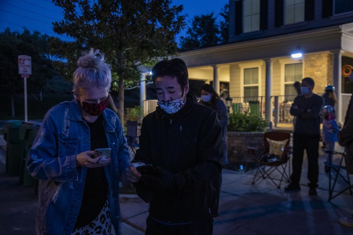  Layla Parks and Dave Uemura check the list of time slots for the Mocha Watch Crew. 