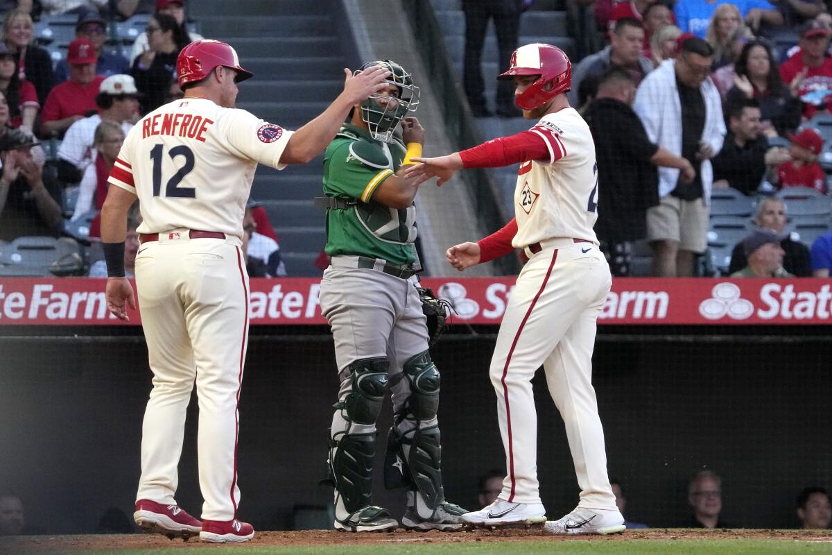 Angels' Hunter Renfroe, left, and Brandon Drury, right, congratulate each other after scoring.