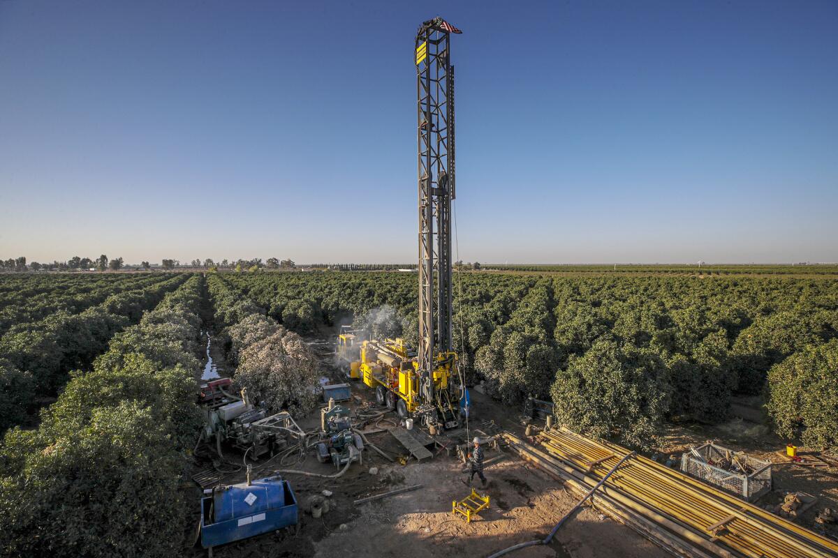 A company drills a well in a pistachio orchard near Terra Bella, Calif., in 2021.