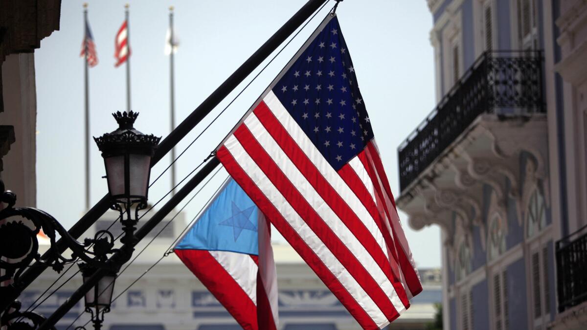 U.S. and Puerto Rico flags hang outside the governor's mansion in Old San Juan, Puerto Rico, on June 29, 2015.