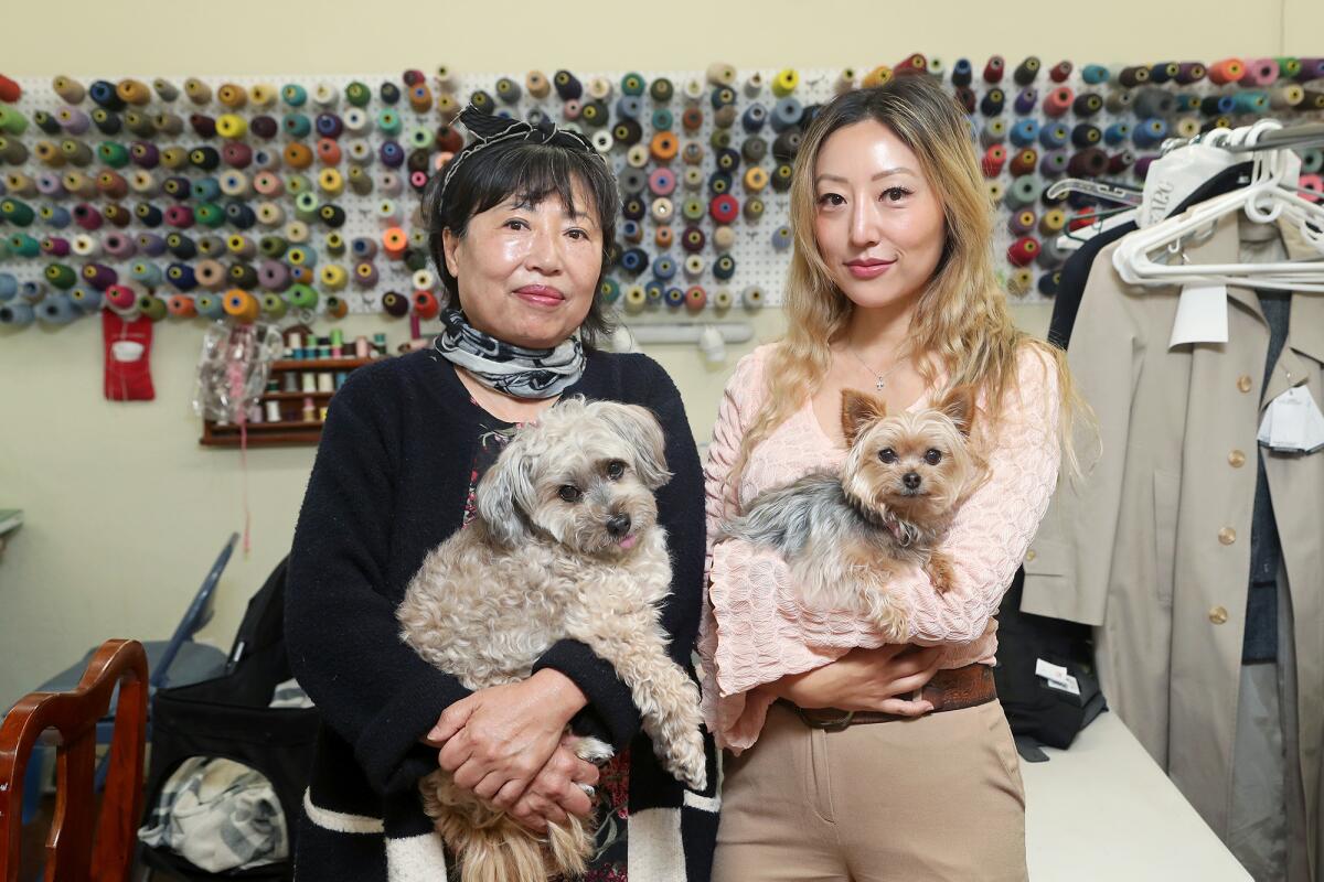 Joyce "Peggy" Cho, 63, of Anaheim and her daughter Sarah, 31, with their dogs Chewy, left, and Minnie at Peggy's Perfect Fit.
