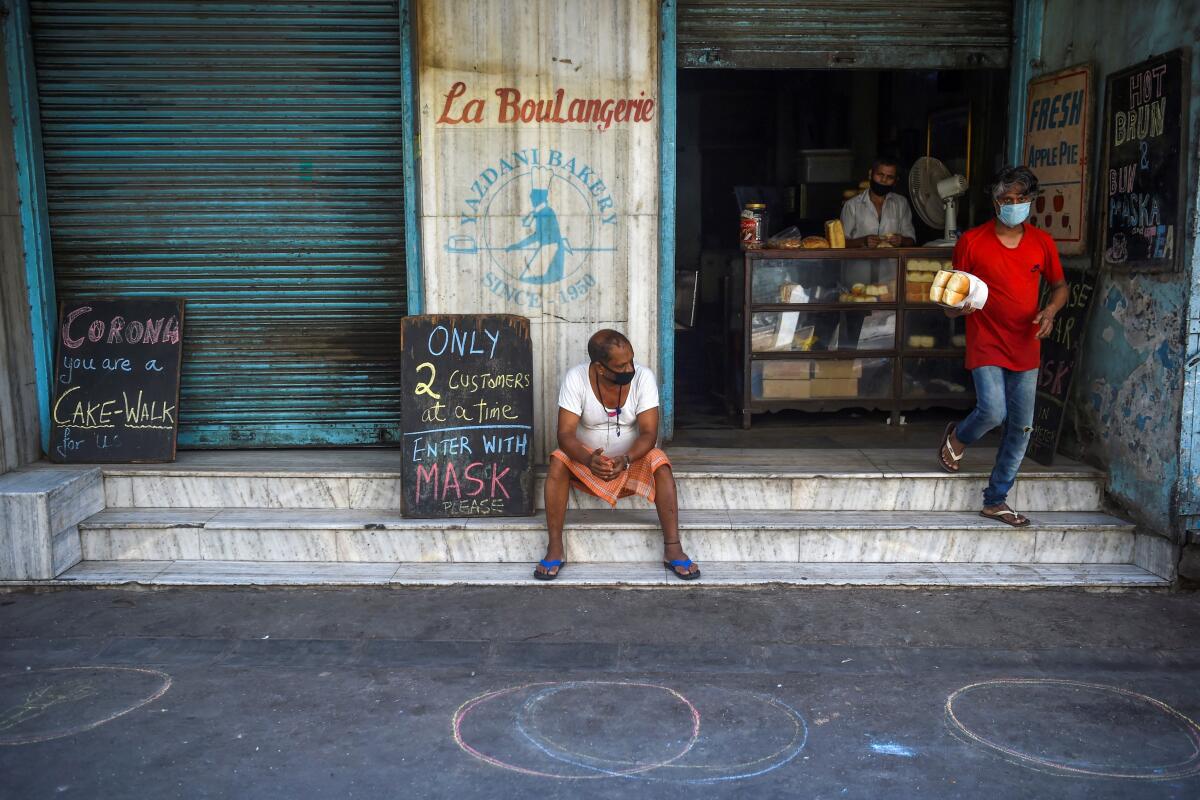 A shopper leaves the Yazdani bakery, one of the oldest in Mumbai, India, during a nationwide lockdown to stop the spread of COVID-19.