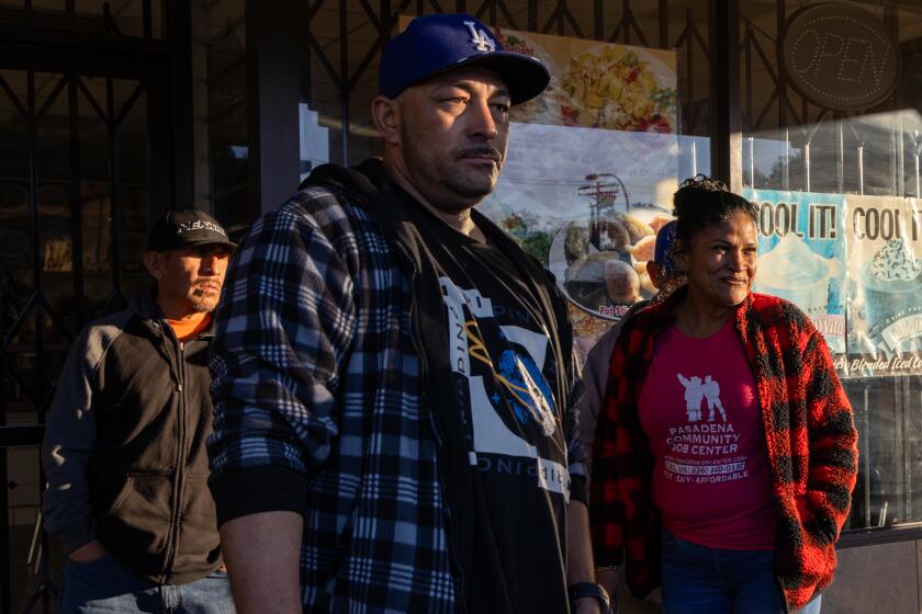 PASADENA, CA - NOVEMBER 17: Day laborers wait for job early morning at a shopping plaza on Friday, Nov. 17, 2023 in Pasadena, CA. (Irfan Khan / Los Angeles Times)