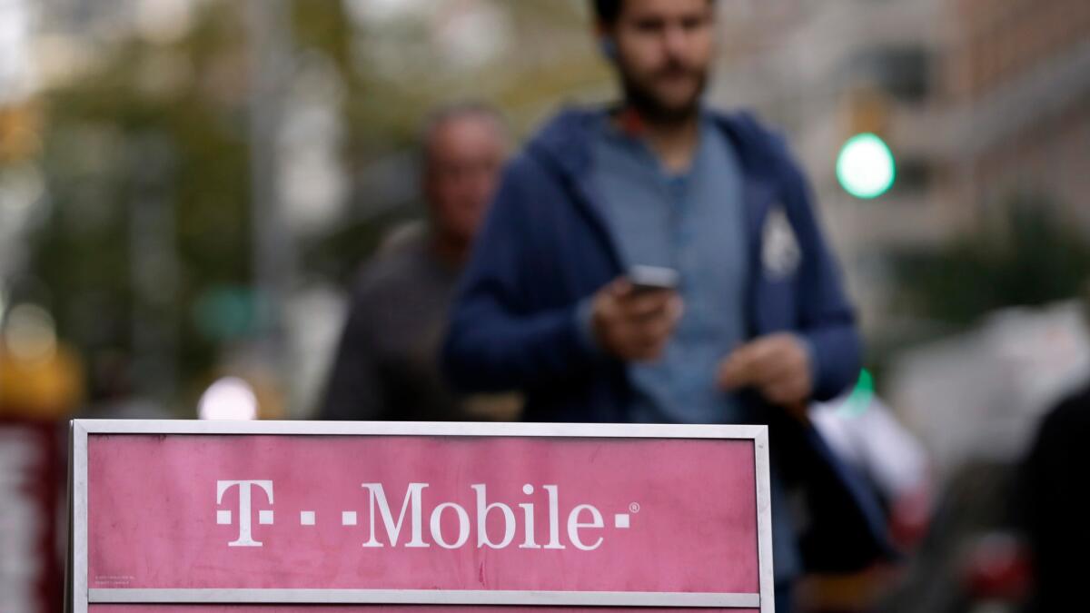 People walk past a T-Mobile store in New York in 2015.