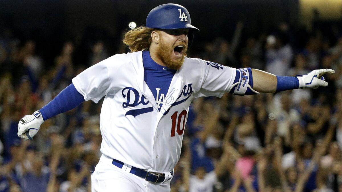 Dodgers third baseman Justin Turner celebrates as he heads to first base after delivering the game-winning hit against the Brewers on Friday night.