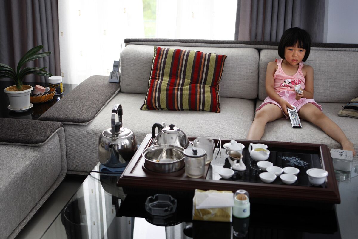 Zhang Yujia, 6, watches cartoons in the house her parents bought in Chao Le village, in eastern China's Fujian province, with a $100,000 interest-free government loan. The rural couple received the money as a reward for agreeing to stick to two girls and not try for a son. For three decades, the world's most populous country has moved aggressively to limit its population growth. Yet the nation's huge and still-growing numbers, along with its rising affluence, are taking a heavy toll on the environment.