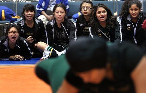 Wrestlers on the Panorama High School girls' team watch a teammate during a tournament at the L.A. Convention Center. "There are still men out there that think women don't belong on the mat," says assistant coach Richard Ramos. "It sounds like boys are tougher, but to be honest, the girls are a lot tougher than the boys," he says.