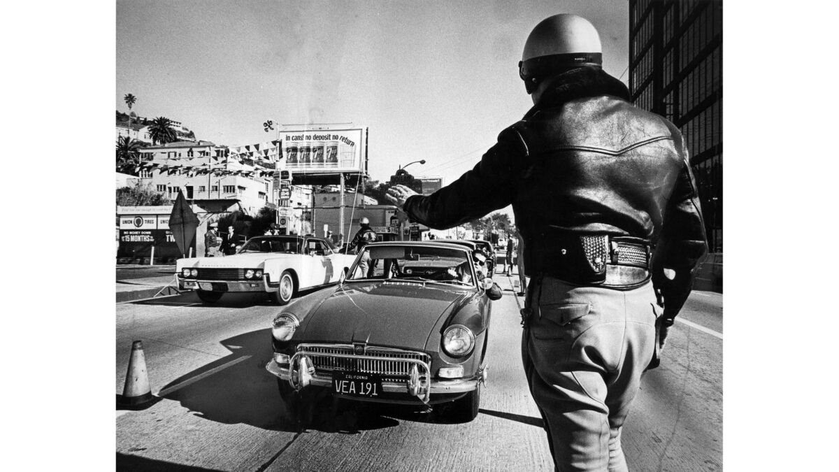 Dec. 22, 1967: California Highway Patrol Officer Wayne Waddell stops cars for inspection on Sunset Boulevard and Sunset Plaza Drive.