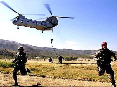 Marines run from a CH-46 Seaknight helicopter after a rope-descending exercise at Camp Pendleton.