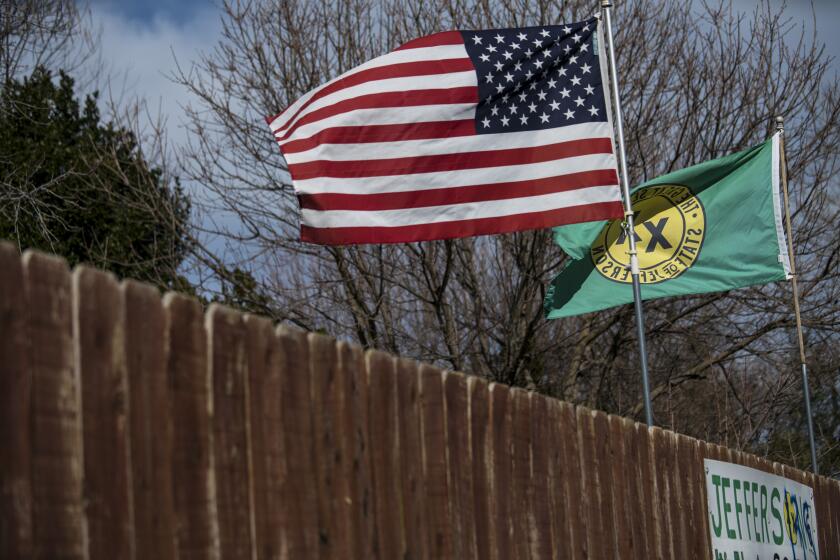 ANDERSON, CA - FEBRUARY 16: The flags of the United States and the "State of Jefferson" are seen flying outside of the Riviera Mobile Estates community on February 16, 2018 in Anderson, California. (Kent Nishimura / Los Angeles Times)