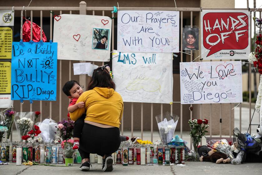 MORENO VALLEY, CA, THURSDAY, SEPTEMBER 26, 2019 -- Vivian Ortiz and her son, Christopher, 1, visit a growing memorial at Landmark Middle School, where a 13 year-old student died after an attack more than a week earlier. (Robert Gauthier/Los Angeles Times)