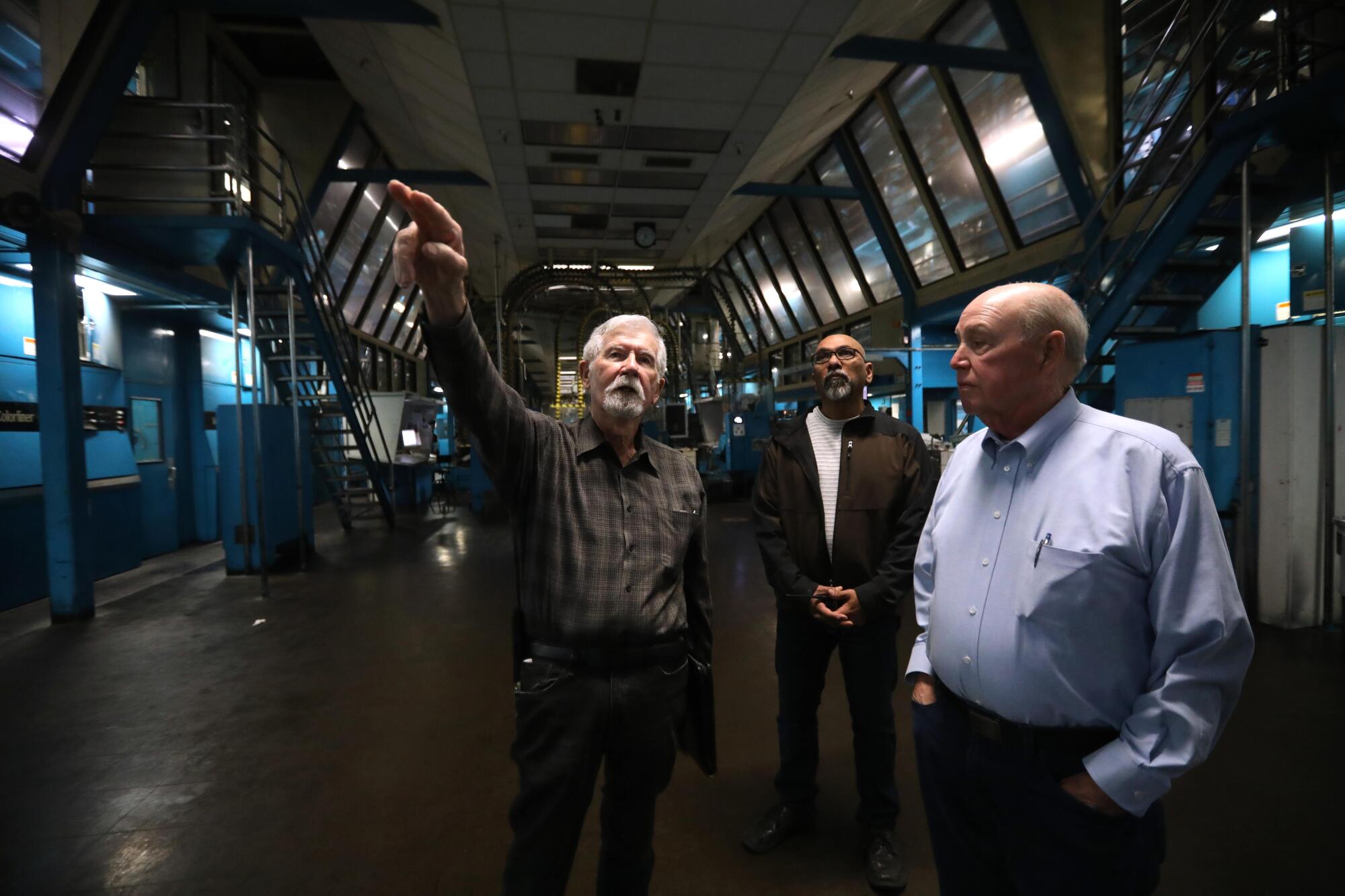 Three men visit the Olympic printing plant 