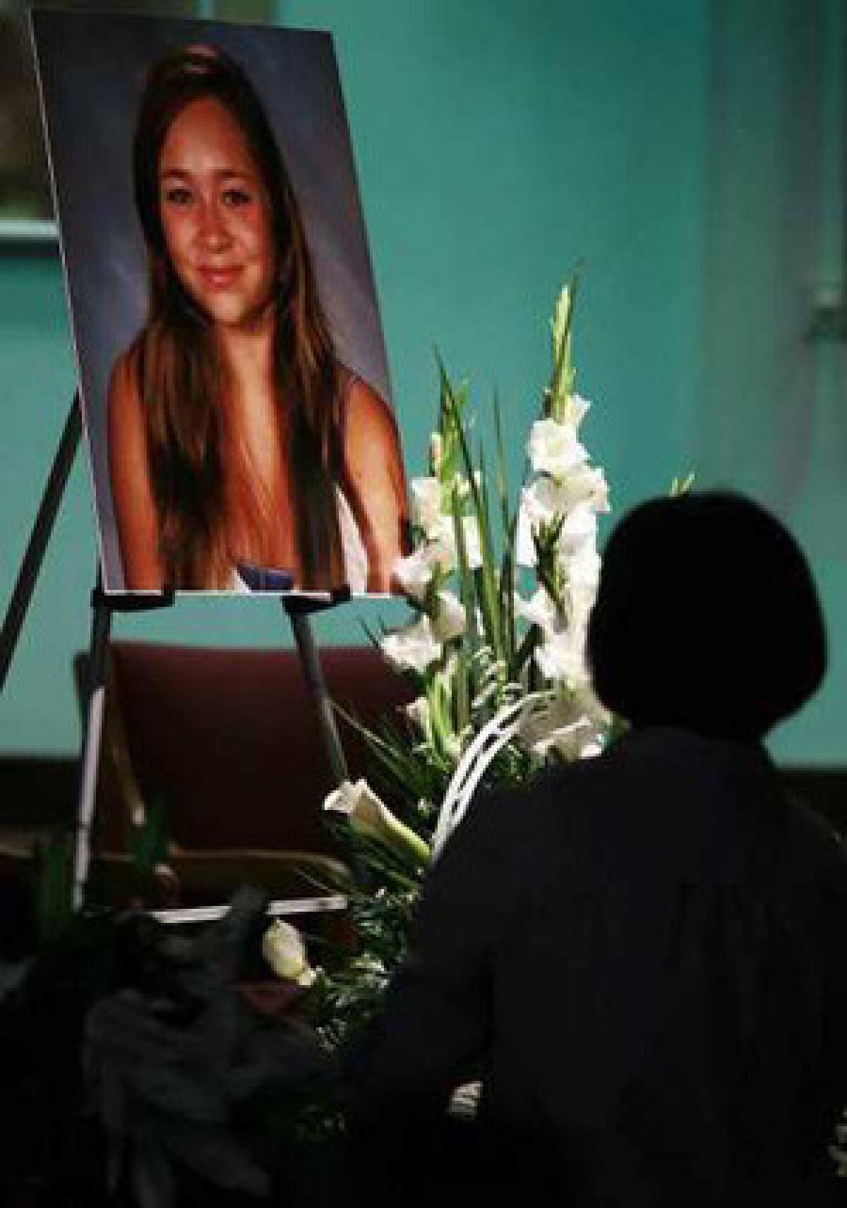 A mourner pauses in front of a picture of Ashton Sweet during a memorial service at the Chinese Baptist Church of Central Orange County in Irvine.