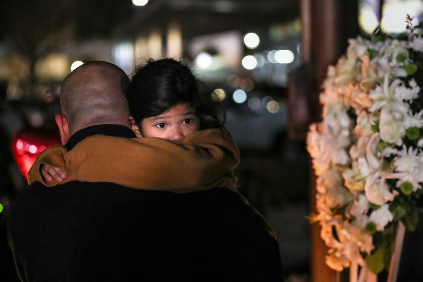 Monterey Park, CA - January 23: A child is carried as mourners take part in a vigil for the victims of a mass shooting at the Star Dance Studio on Monday, Jan. 23, 2023, in Monterey Park, CA. The investigation into a mass shooting in Monterey Park is focused on the gunman's prior interactions at two dance studios he targeted and whether jealousy over a relationship was the motive, law enforcement sources said.(Allen J. Schaben / Los Angeles Times)