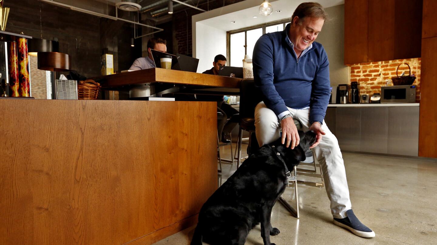 Christopher Rising of Rising Realty spends time with his dog Taylor at the company's offices in downtown L.A.