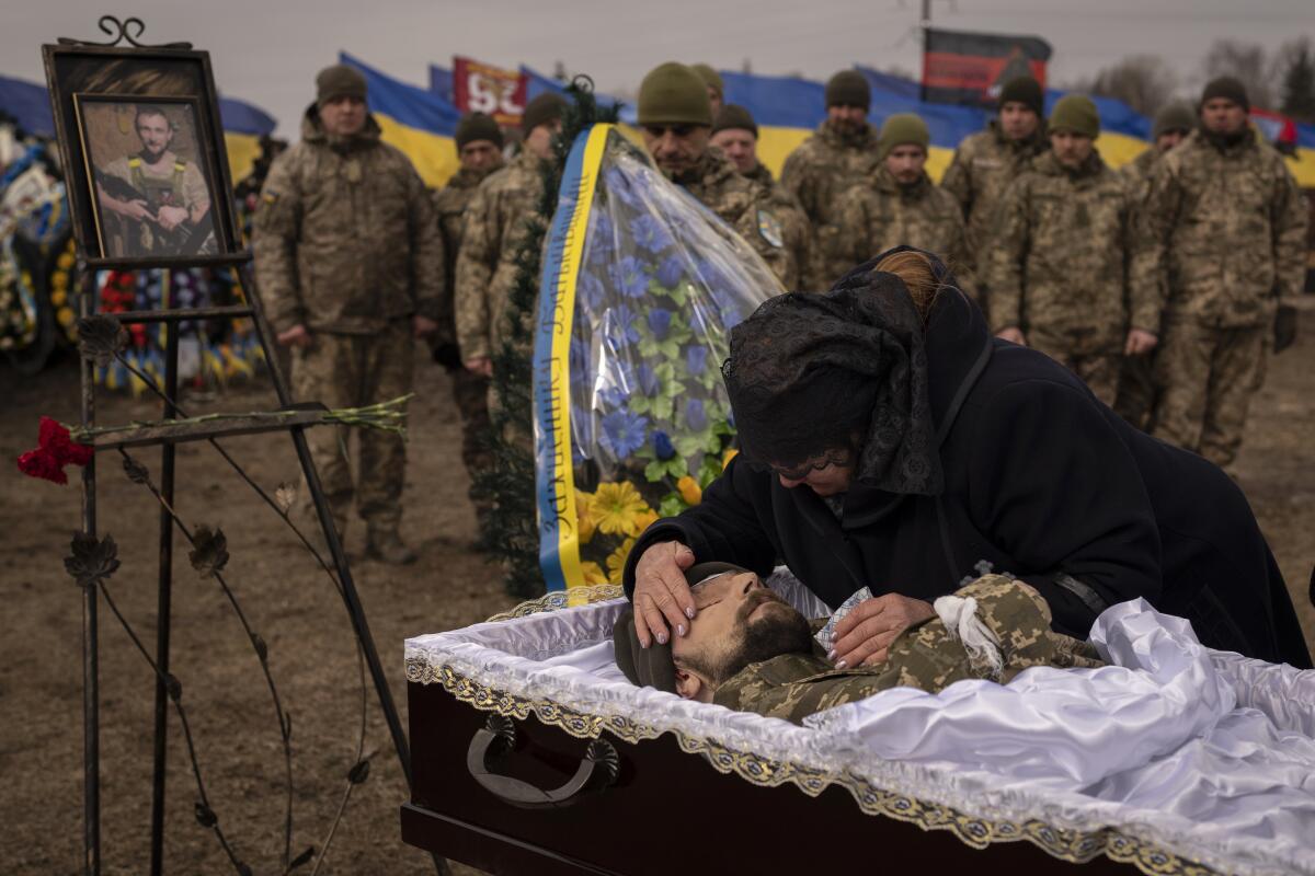 A woman mourns over the body of her son, a Ukrainian soldier.