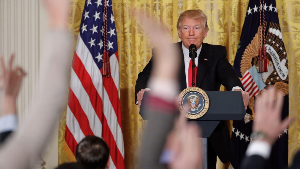 Reporters raise their hands as President Donald Trump fields questions during a news conference in Washington on Feb. 16.
