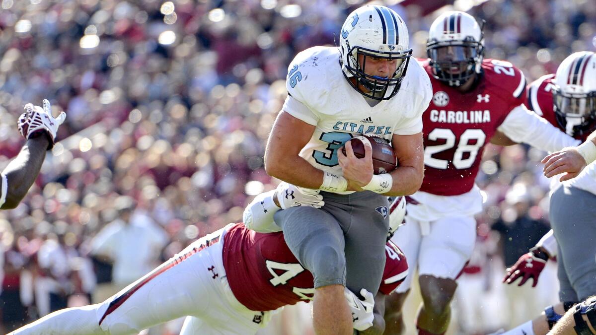 Citadel running back Tyler Renew escapes a tackle attempt by South Carolina linebacker Gerald Dixon to score a touchdown in the first half Saturday.