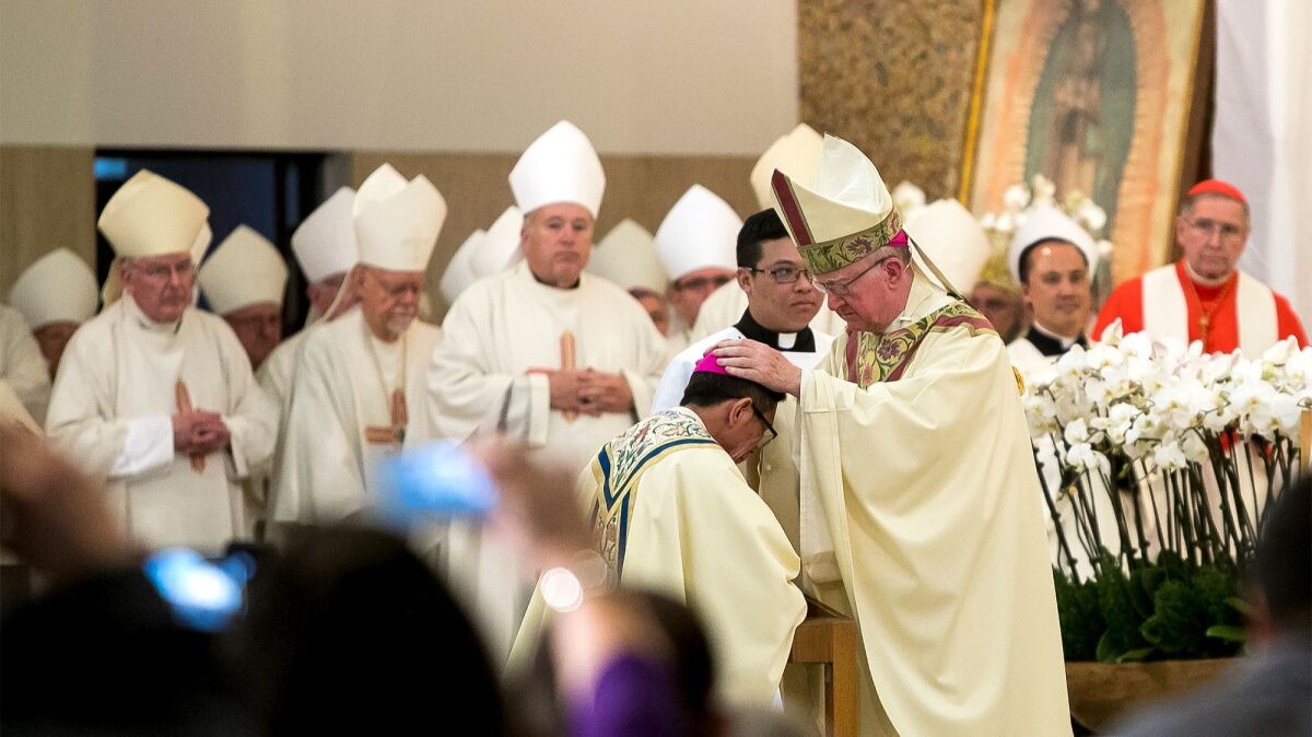 The Rev. Kevin Vann, bishop of Orange, lays his hands on the head of the Rev. Thomas Thanh Nguyen during Nguyen's ordination as auxiliary bishop in the diocese, home to an estimated 70,000 Vietnamese American Catholics.