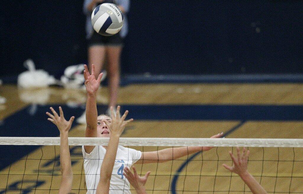 Corona del Mar High's Jessie Harris hits over Newport Harbor defenders during the Battle of the Bay girls' volleyball match on Saturday.