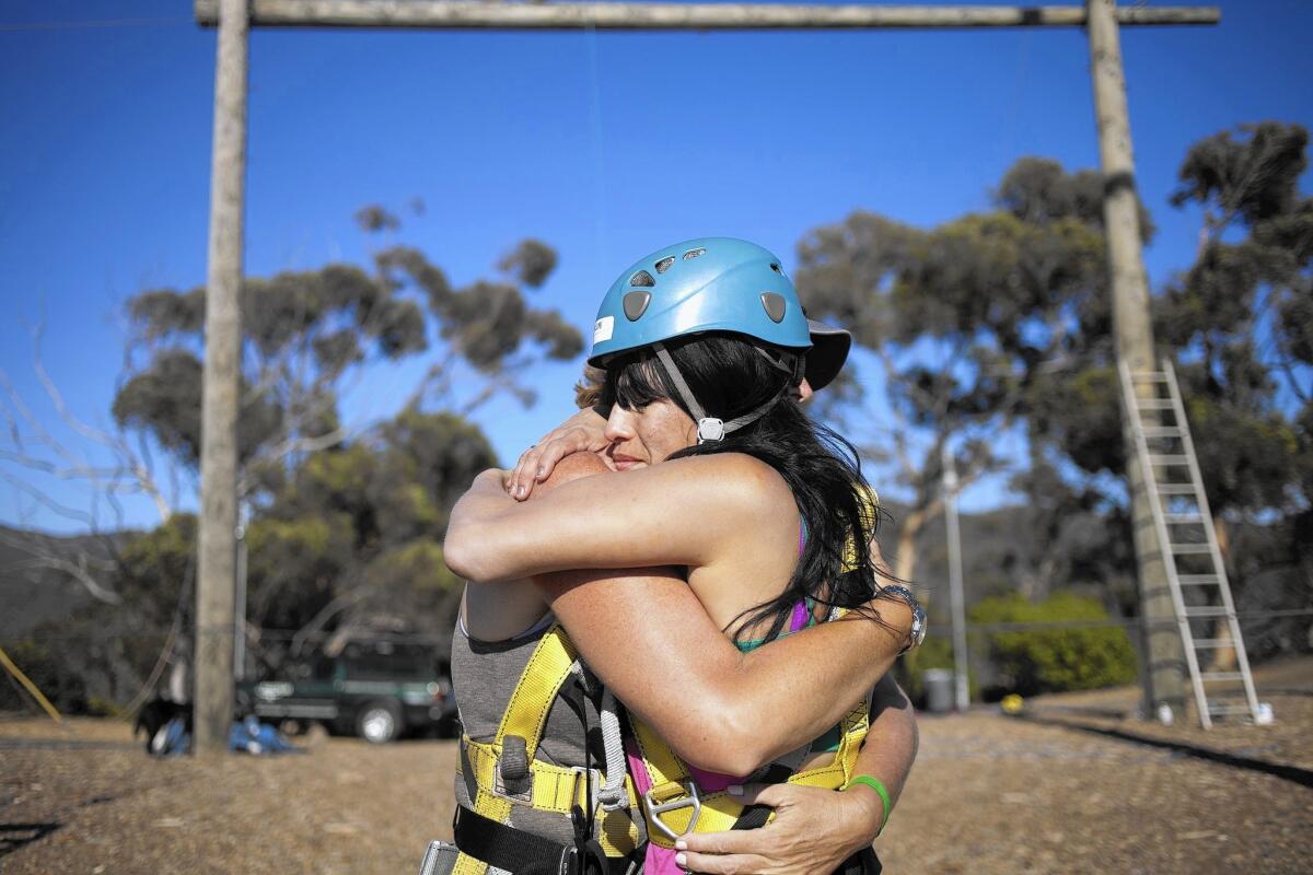 Angela Piatelli, left, of Naples, Fla., hugs Wendy Rea, of Los Angeles, after Rea completes the swing section of the ropes course at the Gindling Hilltop Camp during Campowerment in Malibu.