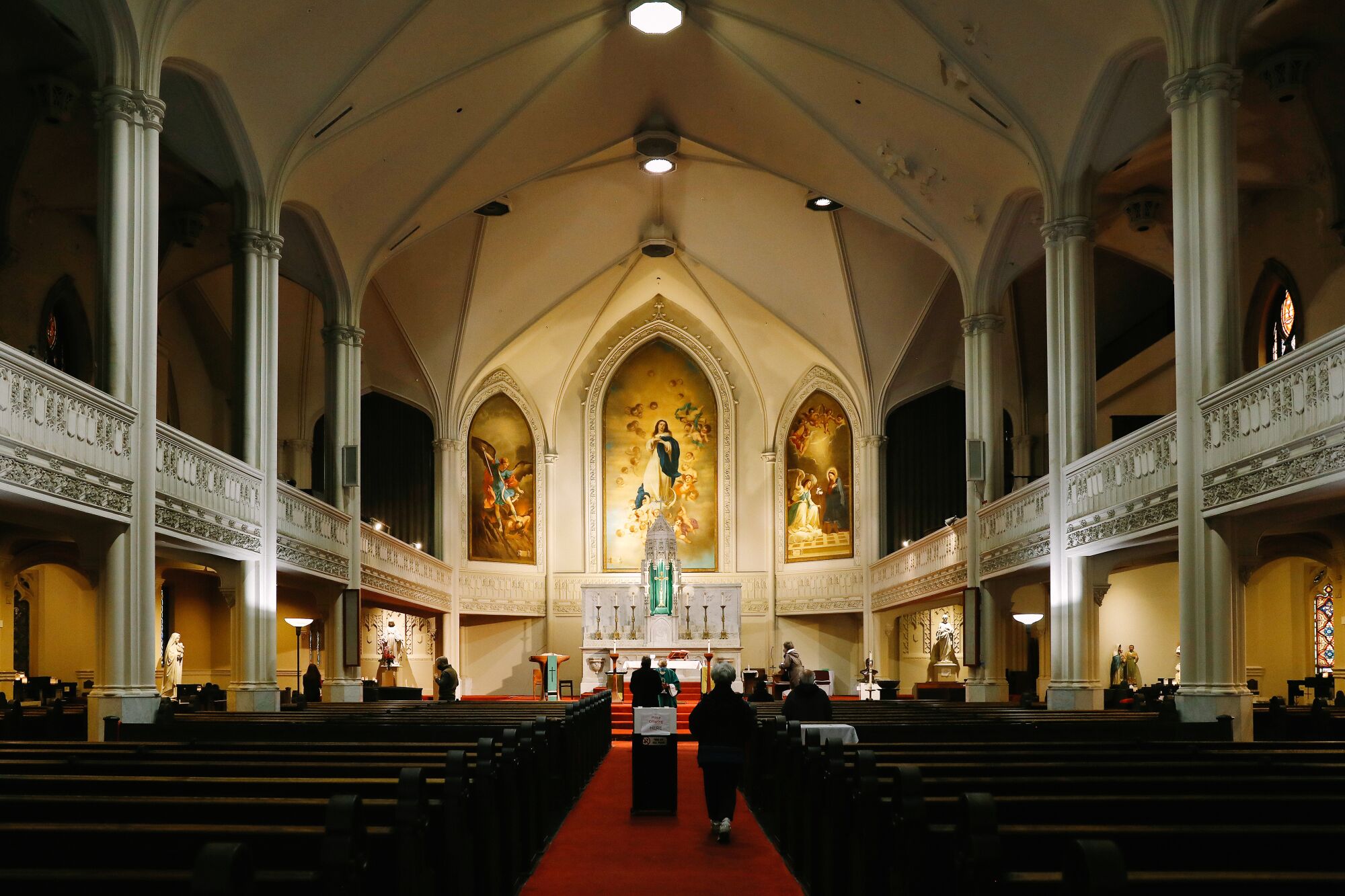 A church interior with gold paintings above the altar.