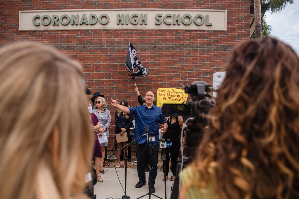 A man speaks in front of reporters at Coronado High School