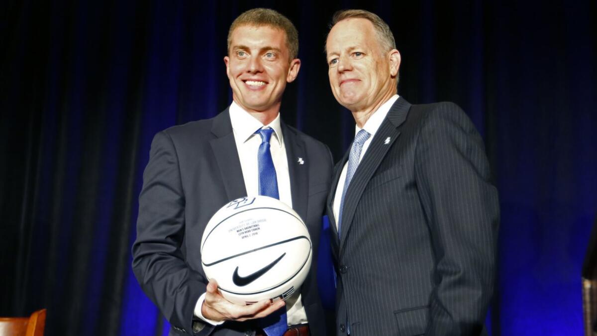 USD Athletic Director Bill McGillis, right, found a creative way to sign Sam Scholl as the Toreros basketball coach.