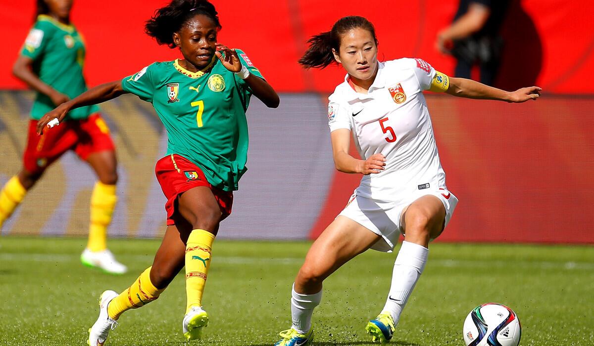 China's Wu Haiyan, right, moves the ball past Cameroon's Gabrielle Onguene during the FIFA Women's World round of 16 match on June 20.