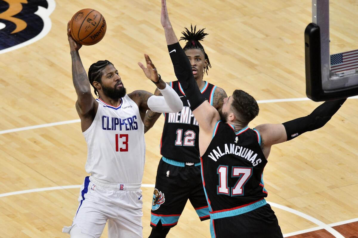 Clippers guard Paul George shoots against Memphis Grizzlies center Jonas Valanciunas and guard Ja Morant.