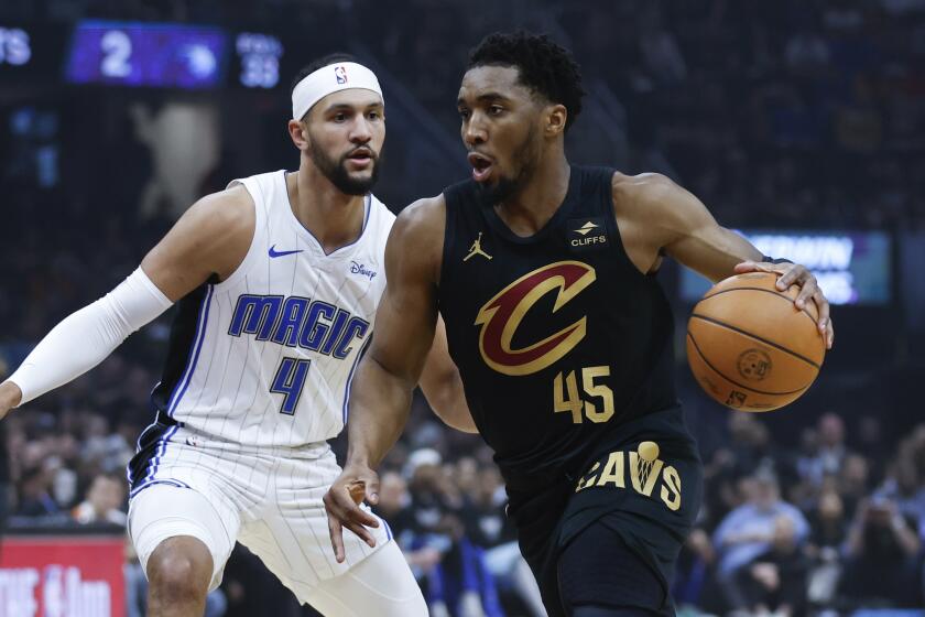 Cleveland Cavaliers guard Donovan Mitchell (45) drives past Orlando Magic guard Jalen Suggs (4) during the first half of Game 5 of an NBA basketball first-round playoff series, Tuesday, April 30, 2024, in Cleveland. (AP Photo/Ron Schwane)
