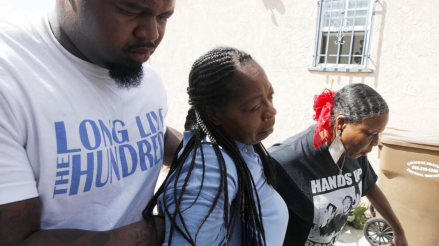 Neighbors brace a distraught Monique Morgan as she visits the scene where her son, Carnell Snell, 18, was fatally shot by police.