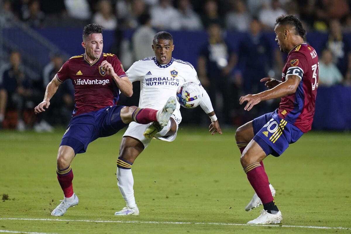 Real Salt Lake defender Bryan Oviedo, left, and Galaxy forward Douglas Costa, middle, vie for the ball Oct. 1, 2022.