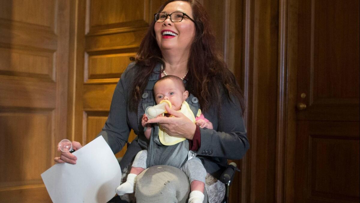 Democratic Senator Tammy Duckworth holds her child, Maile, at a news conference to discuss women's reproductive rights, on Capitol Hill in July of 2018.