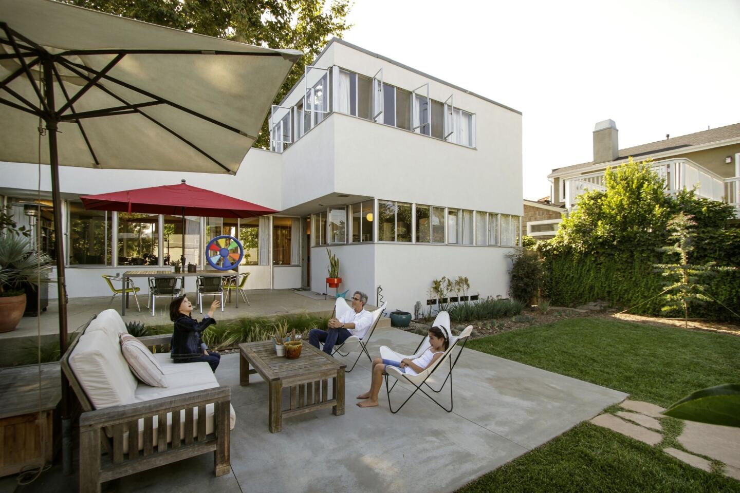 Alan Pullman with daughters Chloe, left, and Sasha in the backyard of their house in the Alamitos Heights neighborhood of Long Beach. The ribbons of glass wrapping the front and back of the house drew the architect's interest.