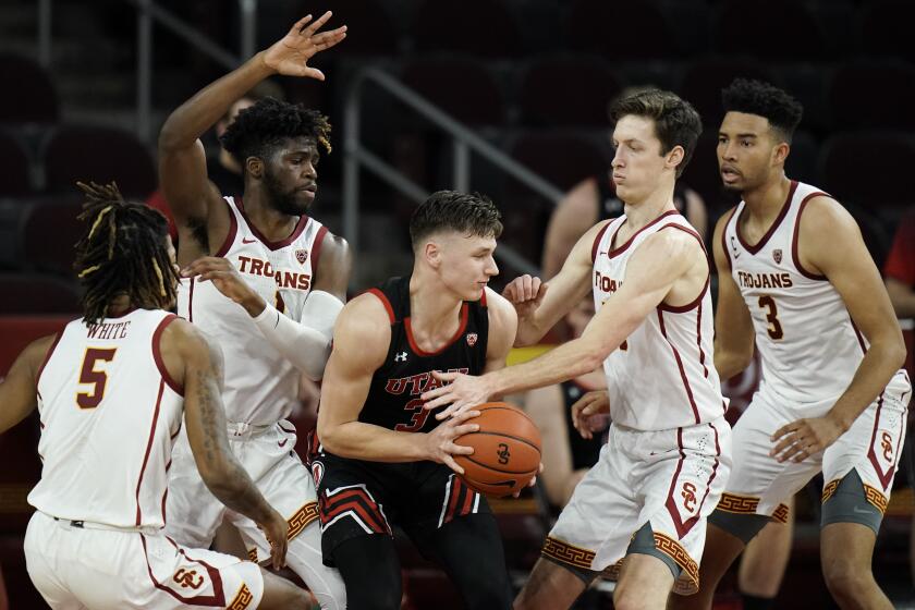 Utah's Pelle Larsson, center, is surrounded by Southern California players during the second half of an NCAA college basketball game, Saturday, Jan. 2, 2021, in Los Angeles. USC won 64-46. (AP Photo/Jae C. Hong)
