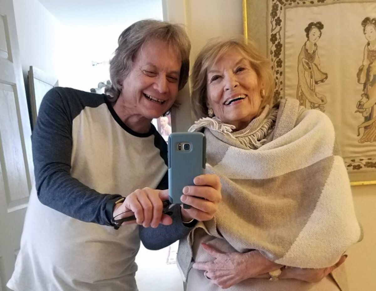 Leland Stein, left, takes a photo with his mother, Sondra Green, in her New York apartment in 2018.