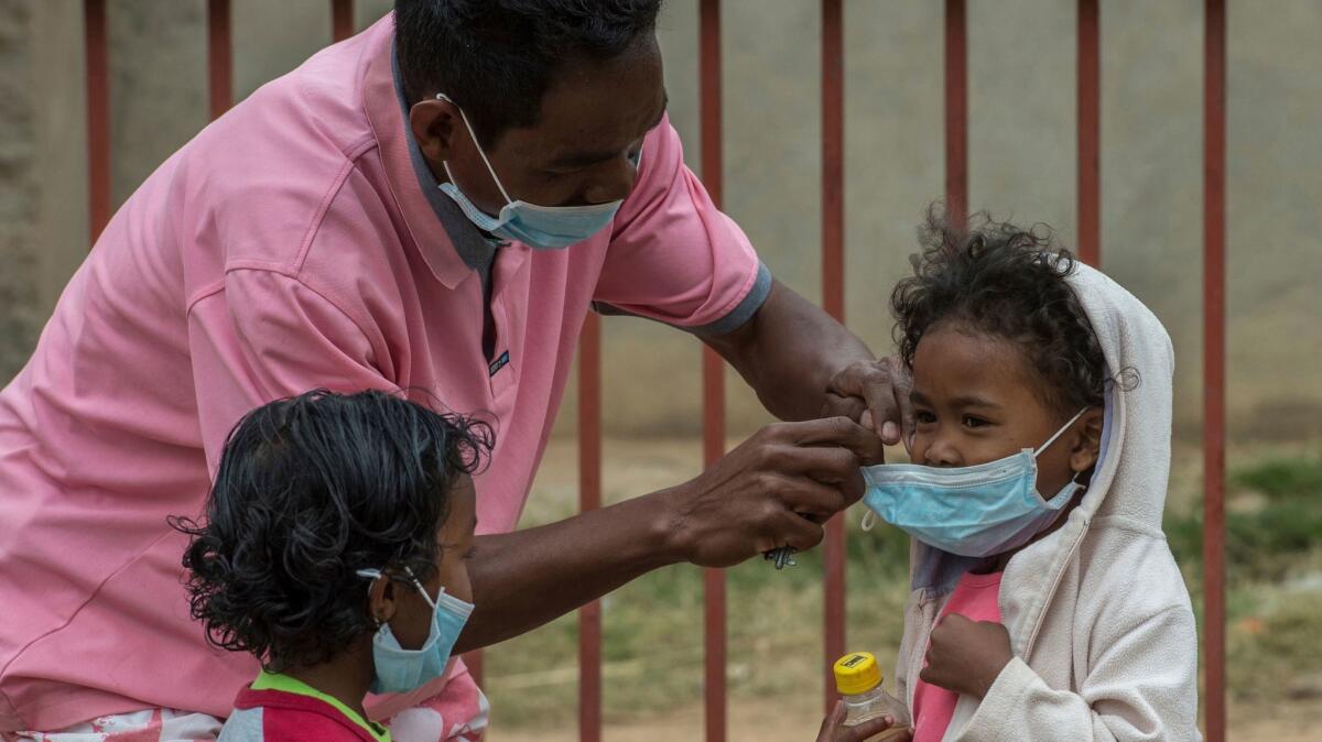 A caregiver places masks on schoolchildren in Antananarivo, Madagascar.