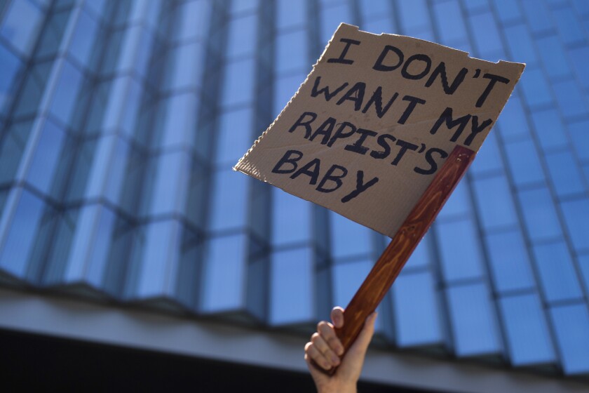 Una mujer levanta un cartel afuera de un tribunal federal en Los Ángeles para protestar contra el fallo de la Corte Suprema
