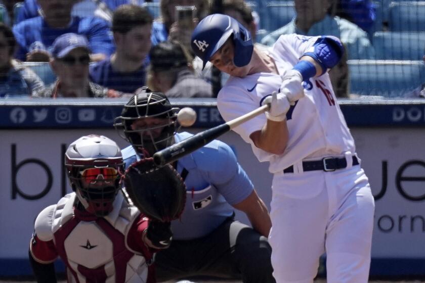 Los Angeles Dodgers' Will Smith, right, hits a solo home run as Arizona Diamondbacks catcher Jose Herrera.